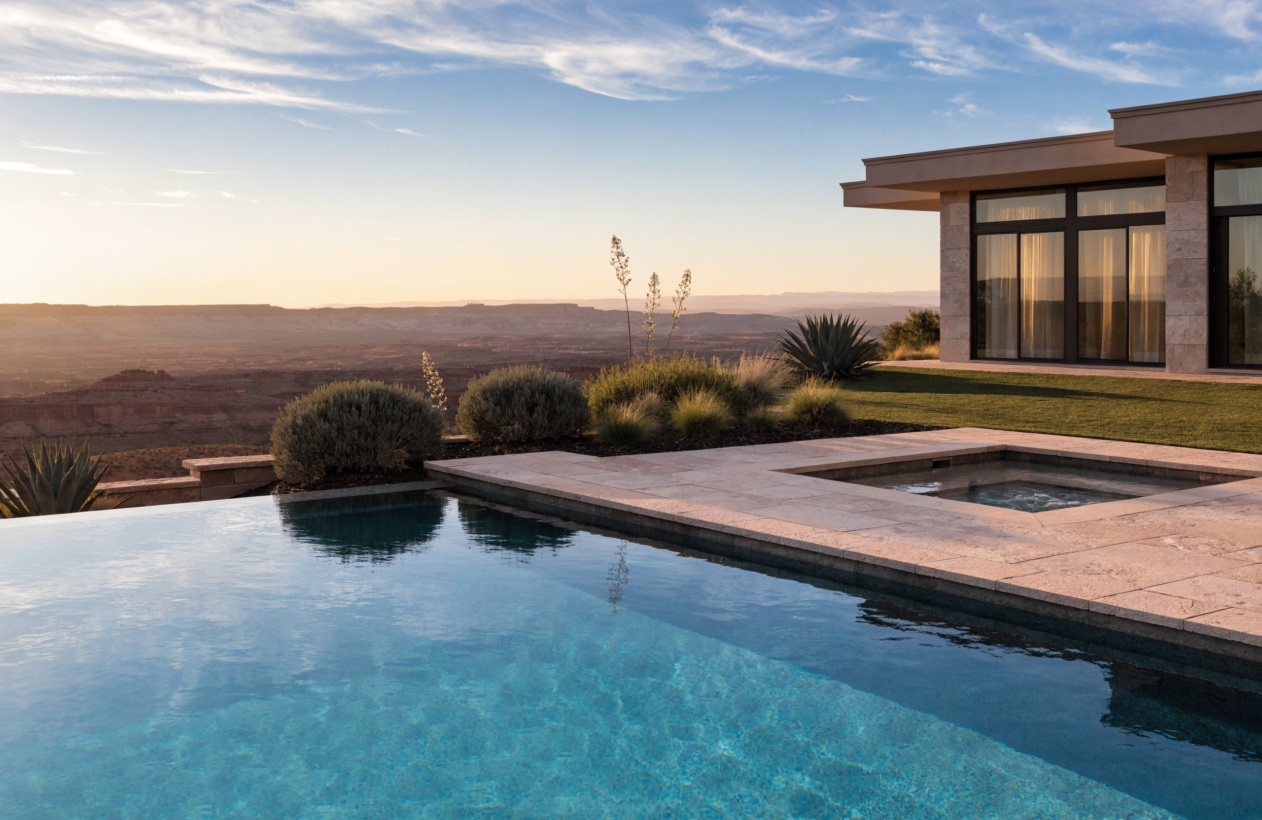 Infinity-edge pool and spa overlooking a red-rock canyon at sunset in Southern Utah